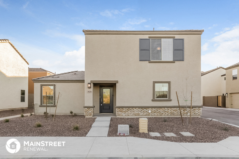 a beige house with a sidewalk in front of it