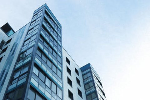 two tall buildings against a blue sky next to each other