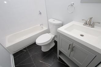 a white bathroom with a sink toilet and bath tub