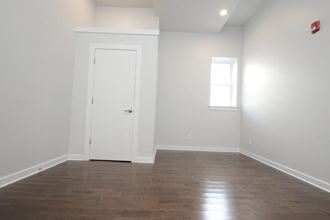 an empty room with white walls and a white door and a window
