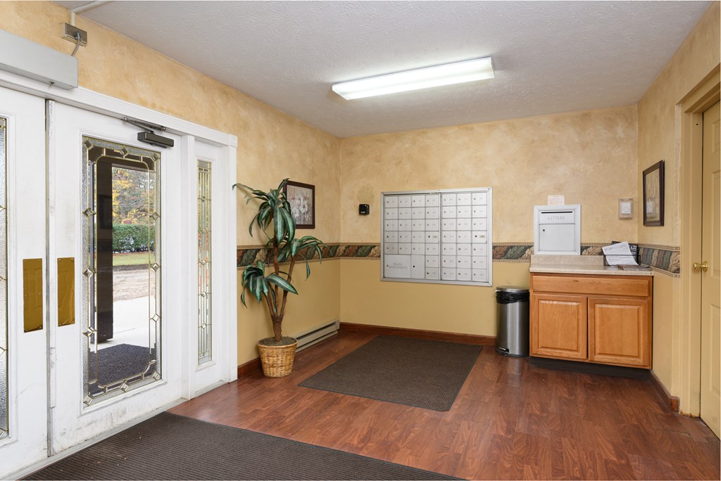 a room with a bulletin board and a door to a kitchen