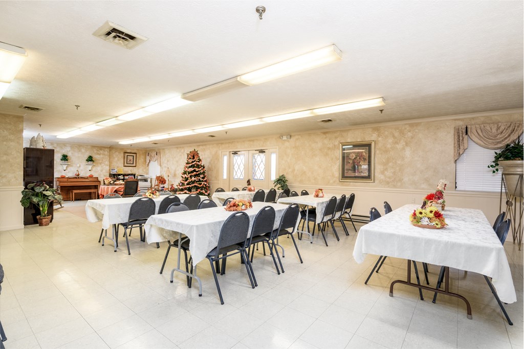 a dining room with tables and chairs and a christmas tree