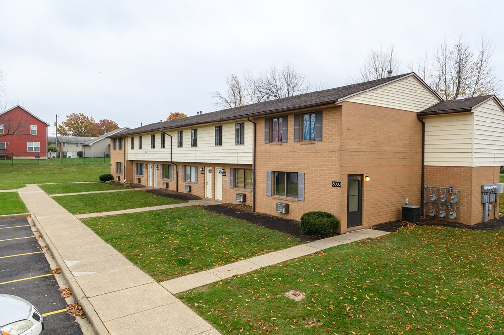 a row of brick apartment buildings on a sidewalk