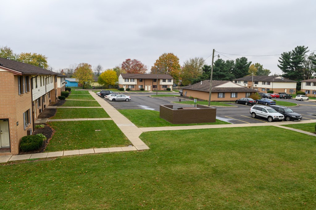 an aerial view of a neighborhood with cars parked in a parking lot