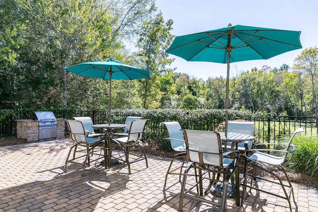 a patio with tables and chairs and umbrellas