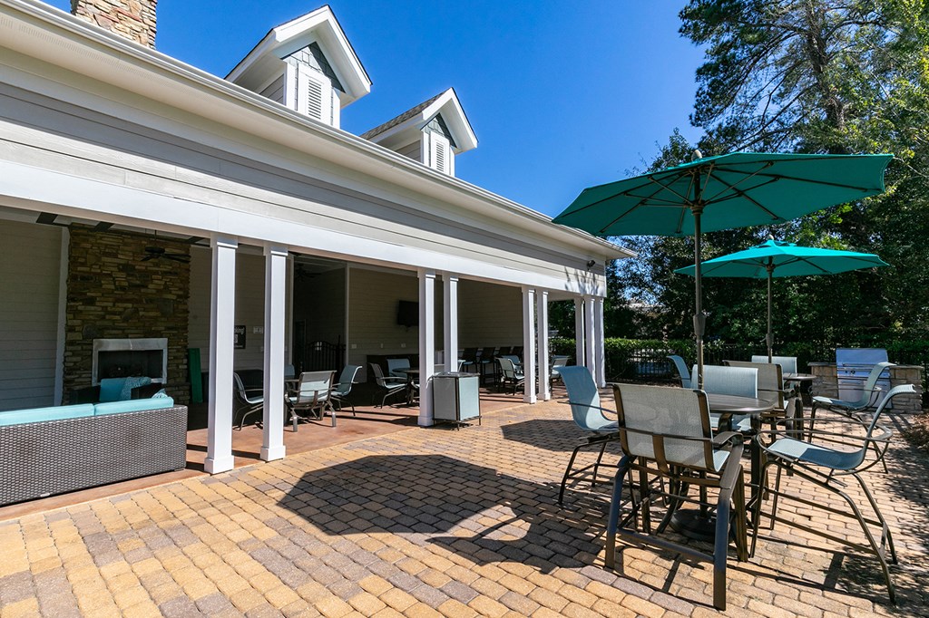 a patio with tables and chairs and umbrellas