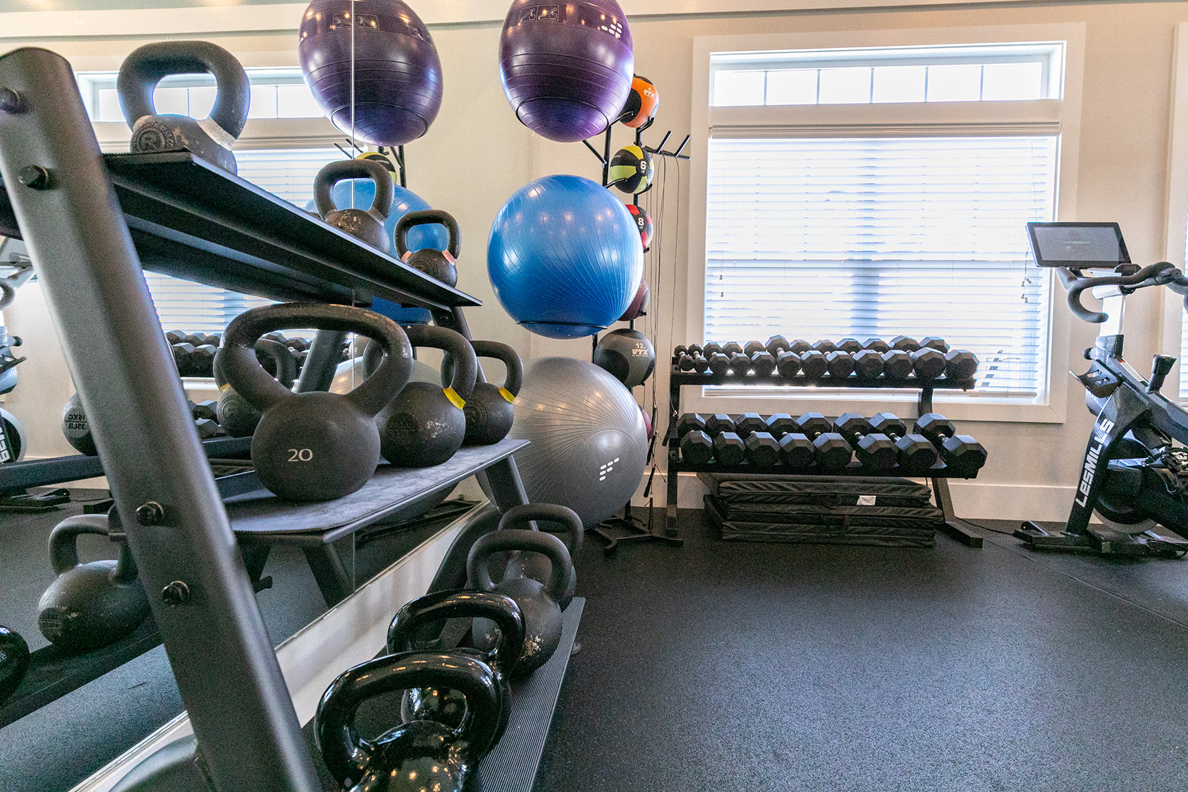 a gym with weights and cardio equipment and a window