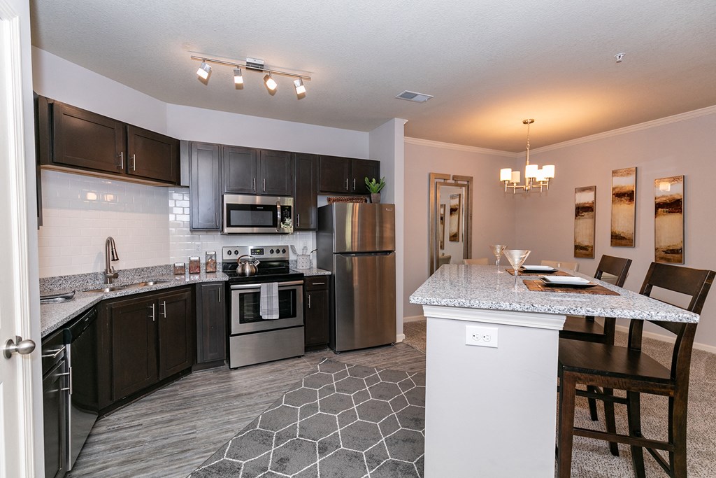 an open kitchen with stainless steel appliances and granite counter tops