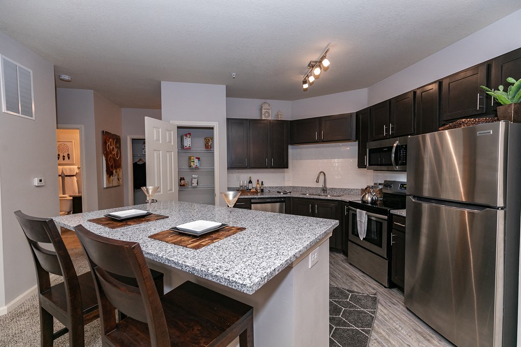 an updated kitchen with stainless steel appliances and granite counter tops