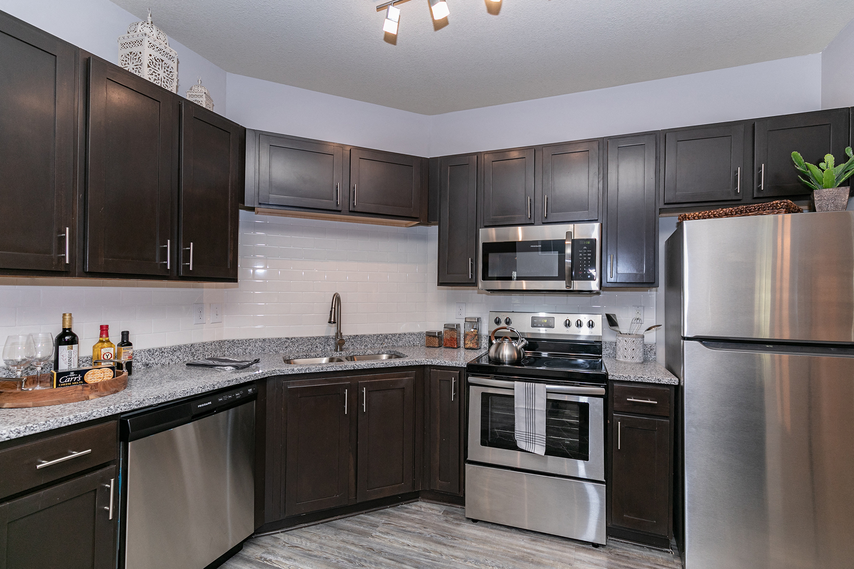 an updated kitchen with stainless steel appliances and granite counter tops