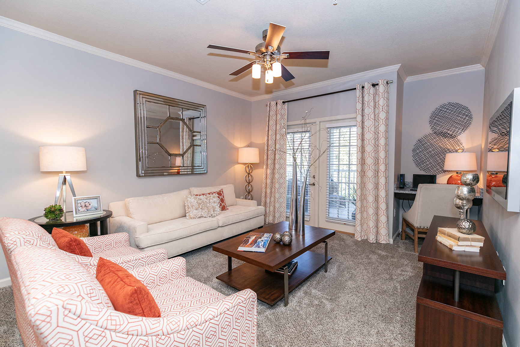 a living room with a couch and a ceiling fan