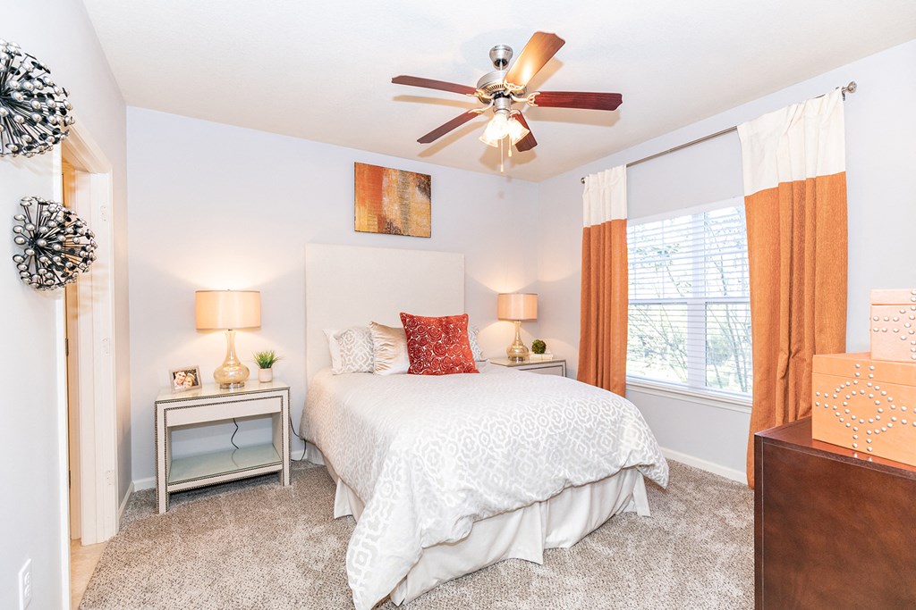 a bedroom with a bed and a ceiling fan