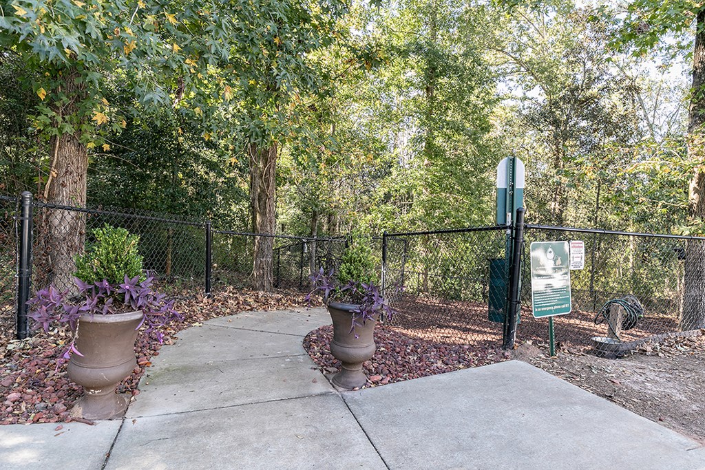 a sidewalk in a park next to a fence