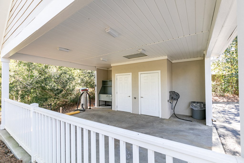 a covered porch with a white door and a gas heater