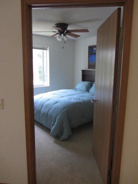 a bedroom with a bed and a ceiling fan