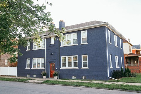 a blue house with white windows and a red door