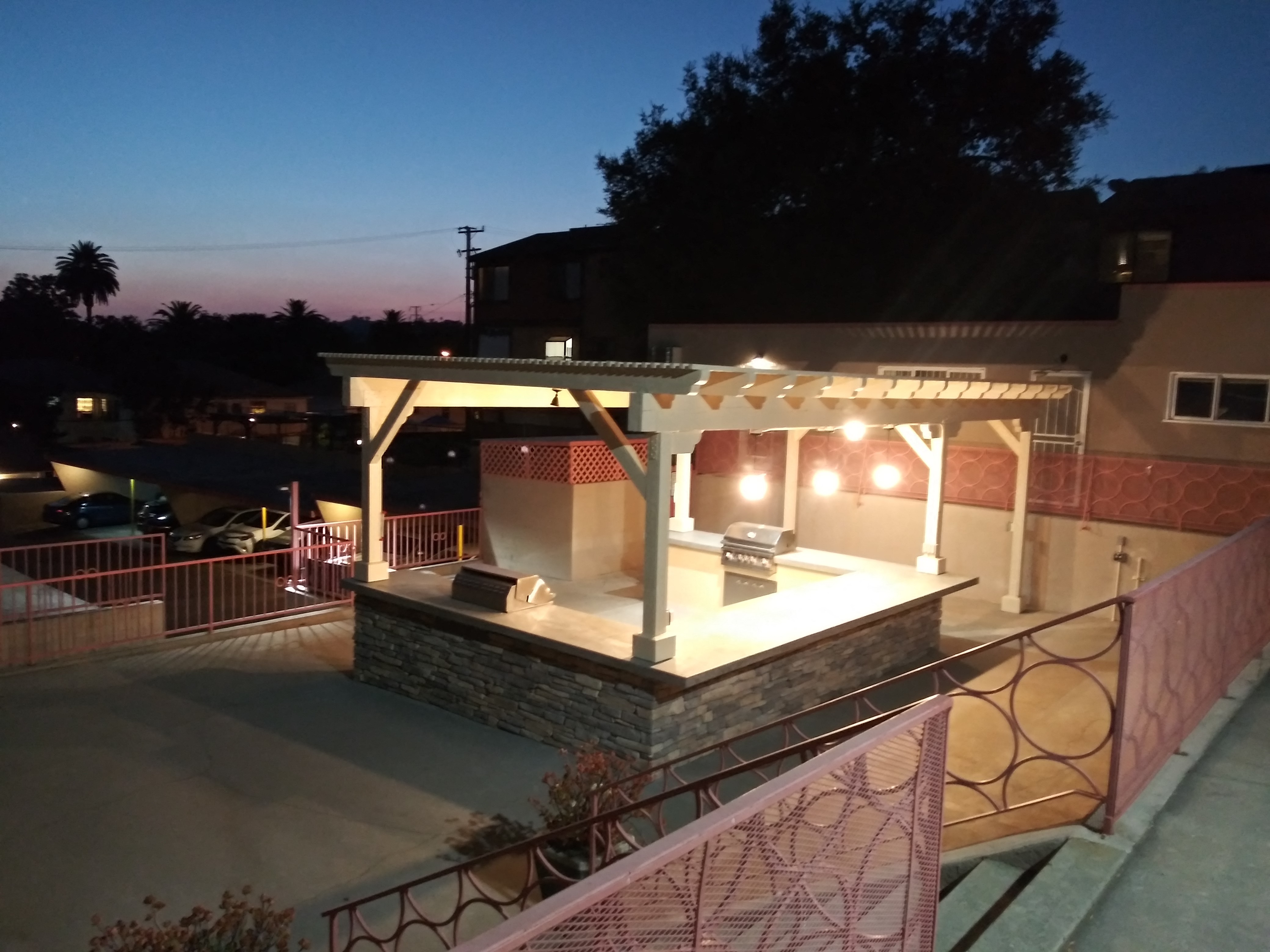 the outdoor bar is lit up at night in the backyard of a house