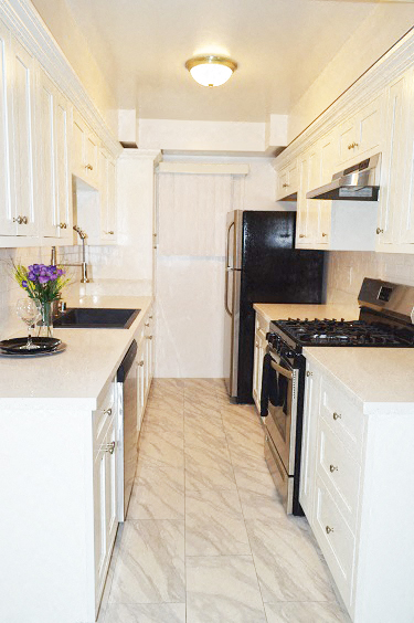 a white kitchen with a stove and a refrigerator