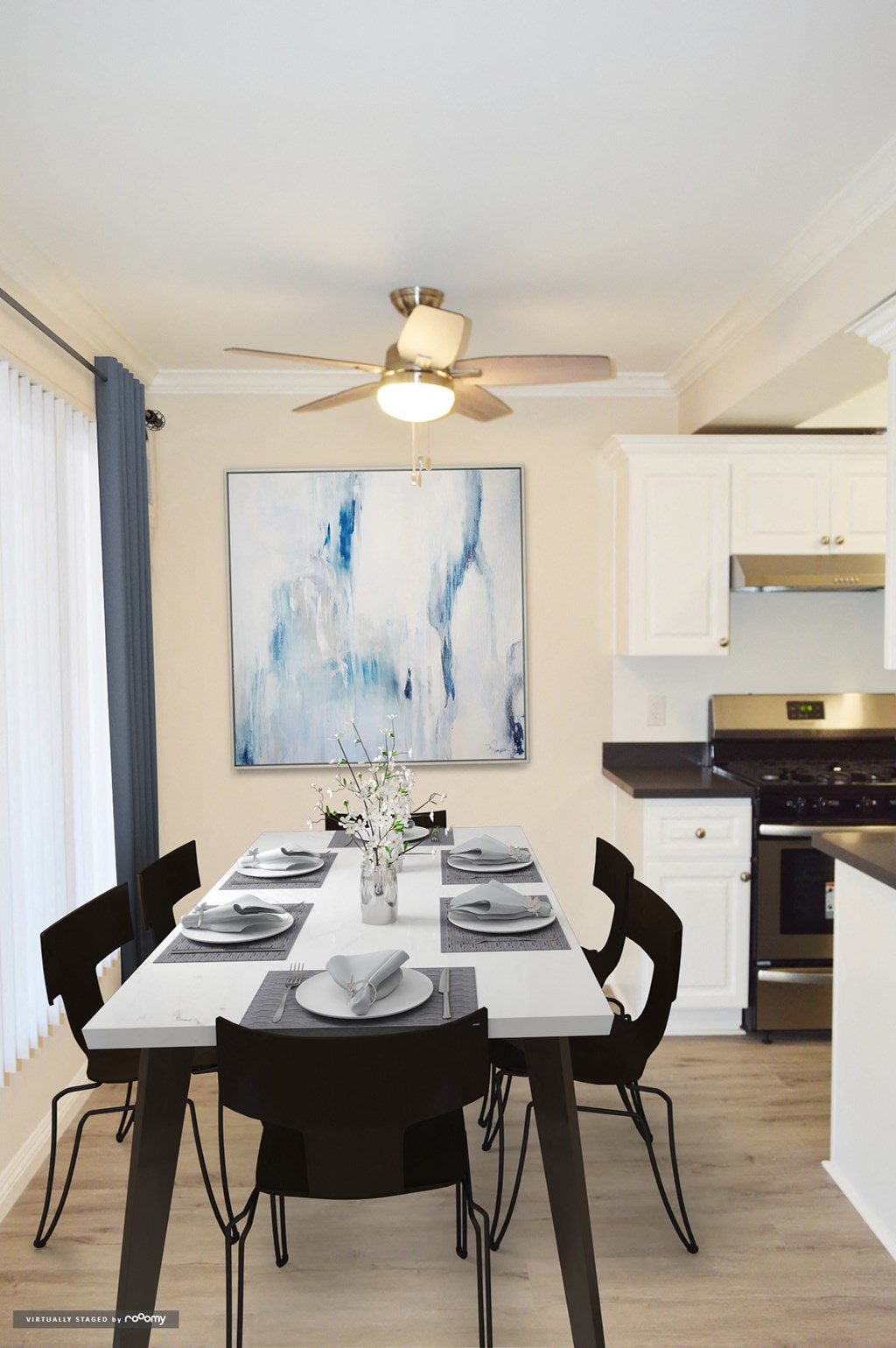 a kitchen and dining room with a table and chairs and a ceiling fan