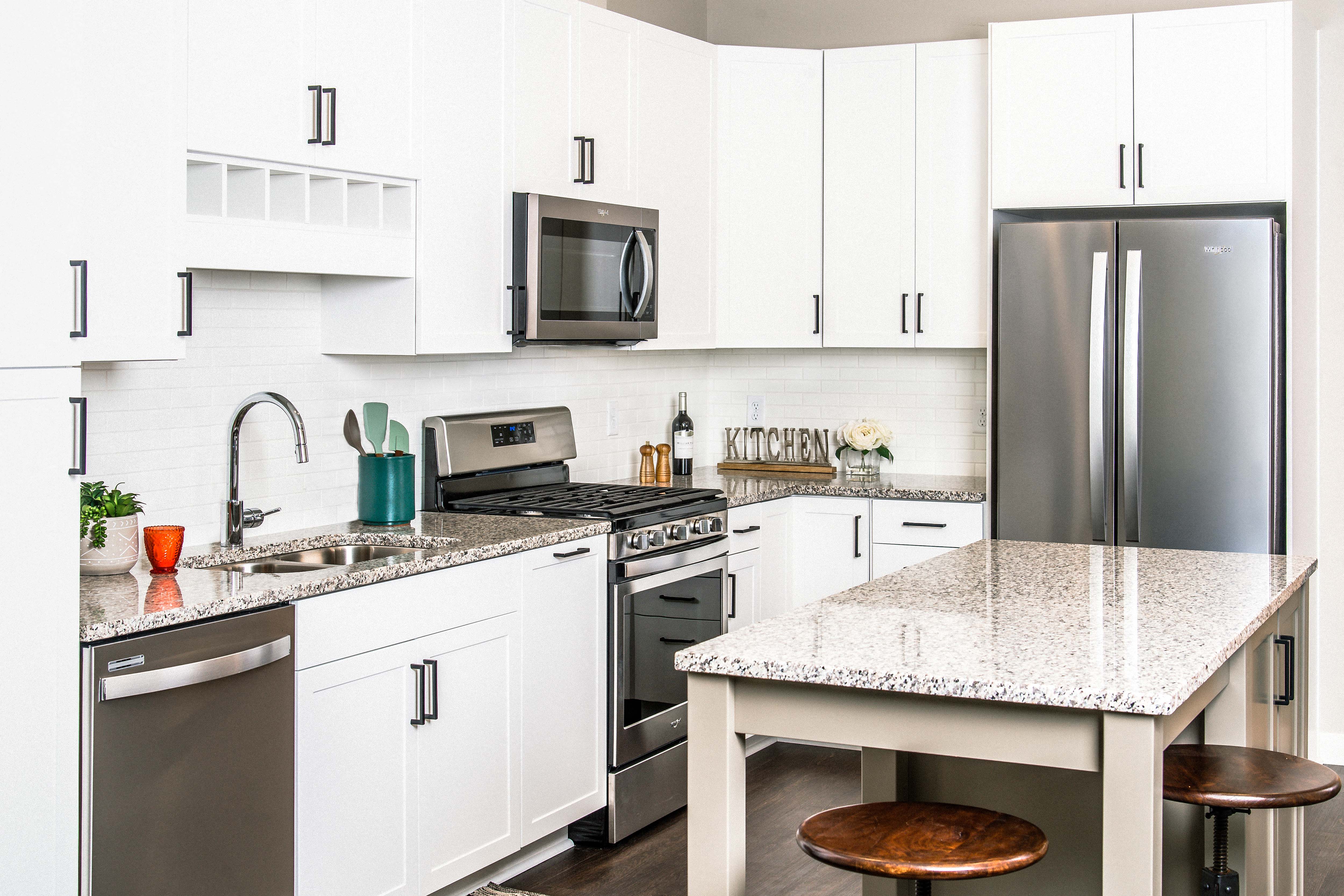 Modern kitchen with sleek stainless steel appliances, granite countertops, a built-in dishwasher, and a stylish gas range. Minnetonka, MN.