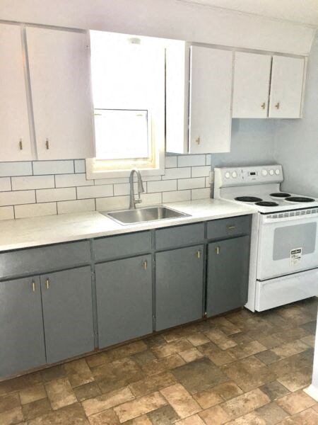 an empty kitchen with white appliances and white cabinets