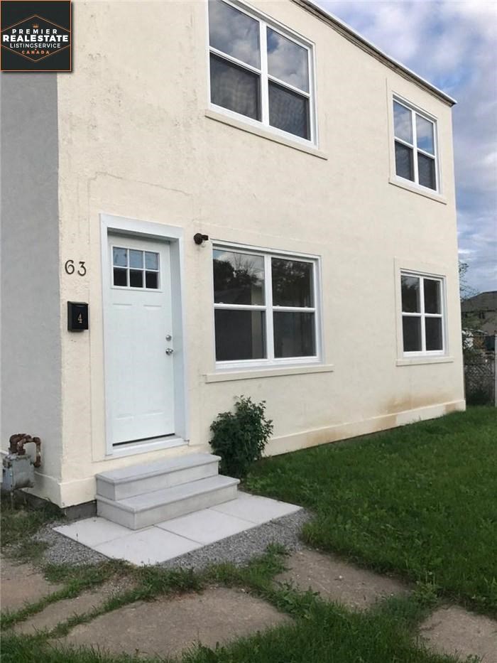 the front of a white house with a white door
