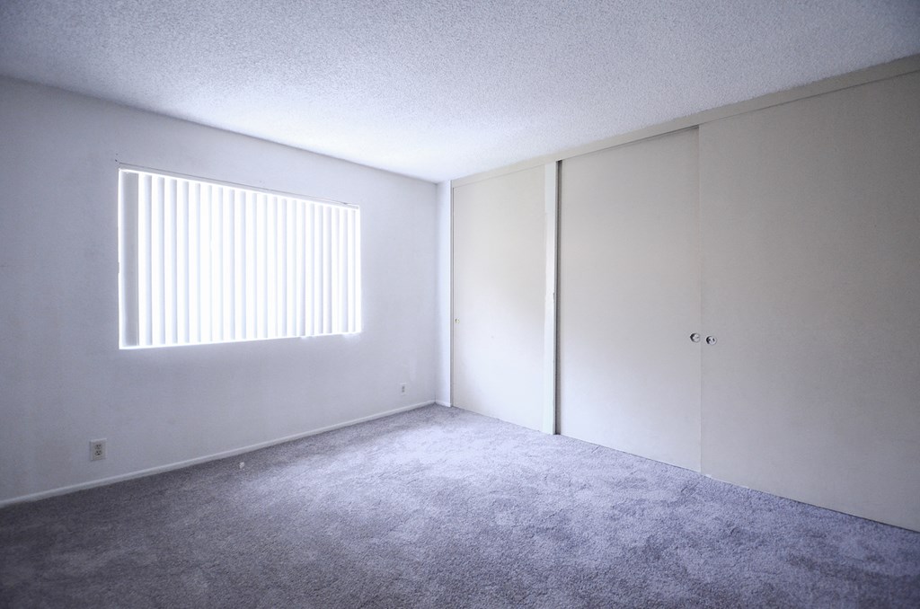 an empty room with white walls and a window
