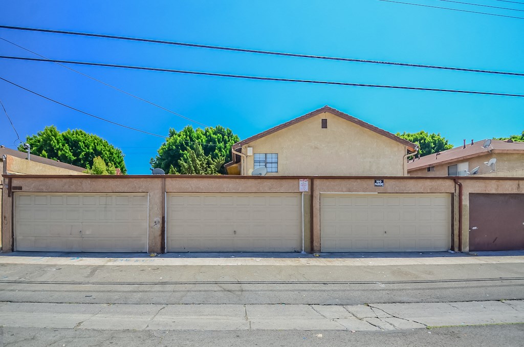 a house with garages and a street in front of it