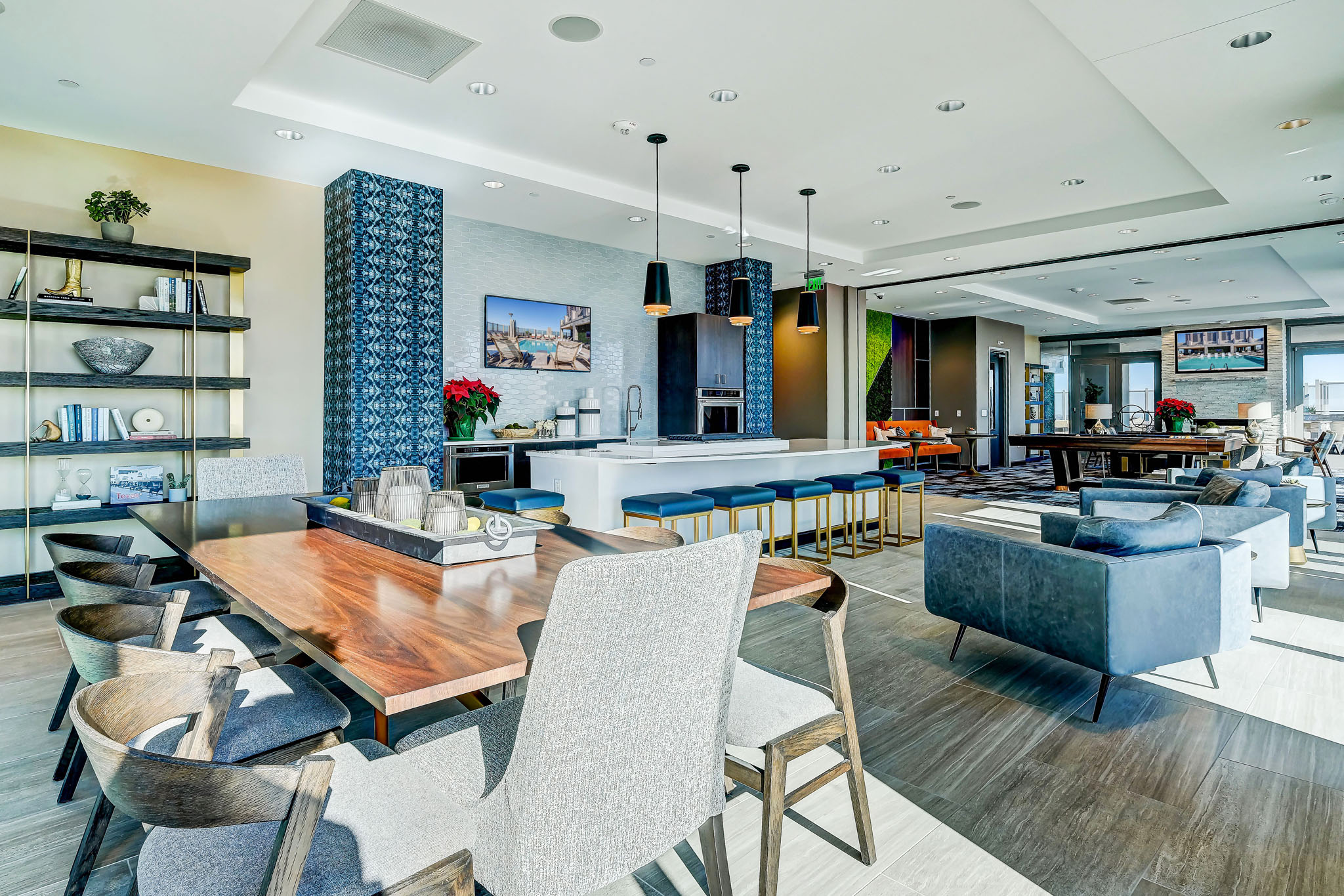 Resident lounge area with bar top seating, catering kitchen, lounge seating, entertainment area, and rooftop pool access
