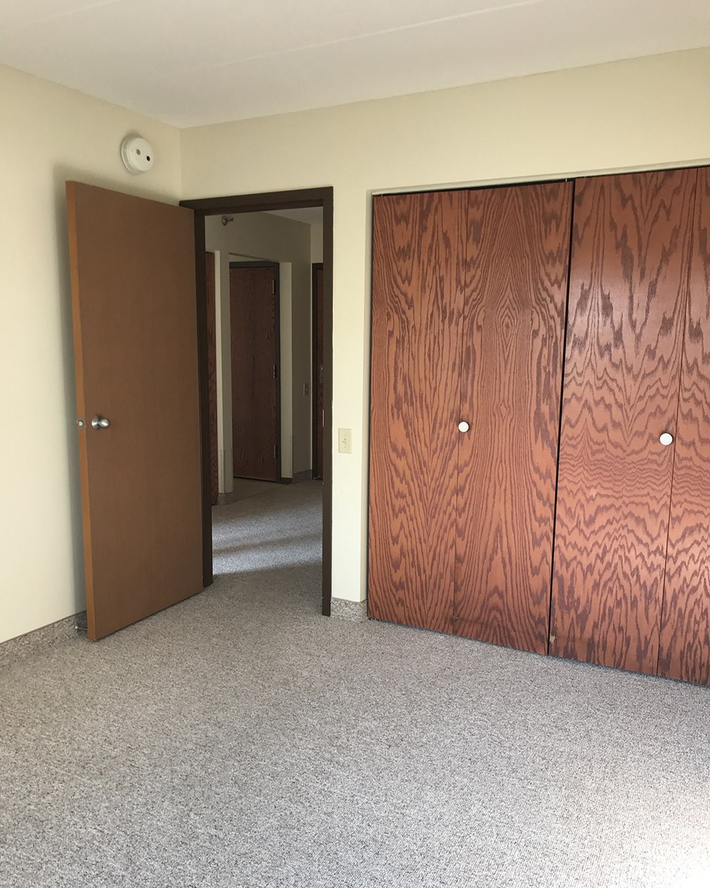 a room with two doors and a hallway with a door open
