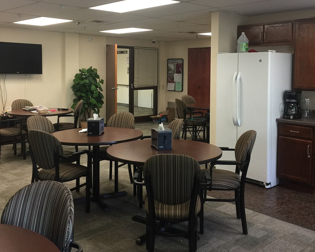 a dining room with tables and chairs and a refrigerator