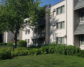 an apartment building with a yard in front of it