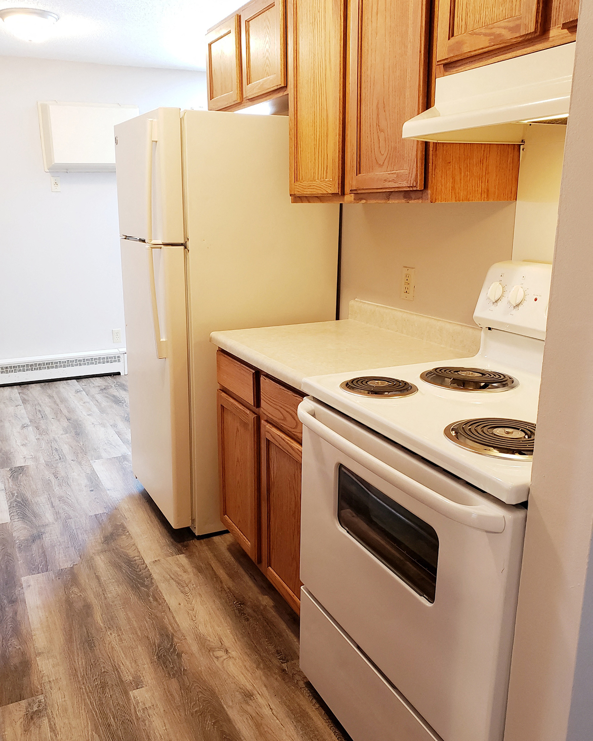 an empty kitchen with a stove and refrigerator