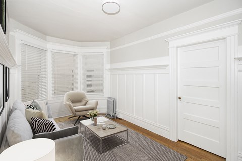 A living room with a grey couch, a chair, and a coffee table.