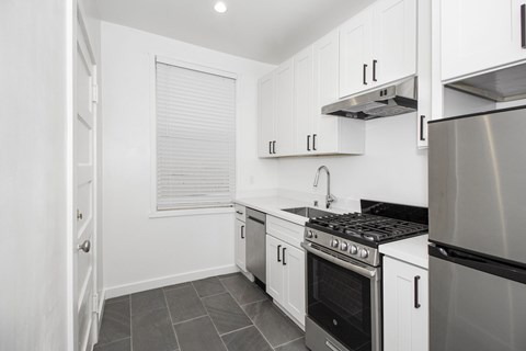 A kitchen with white cabinets and stainless steel appliances.