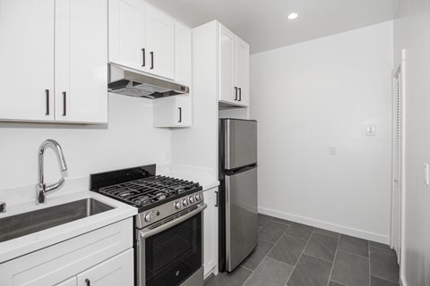 A kitchen with white cabinets and a black stove top oven.