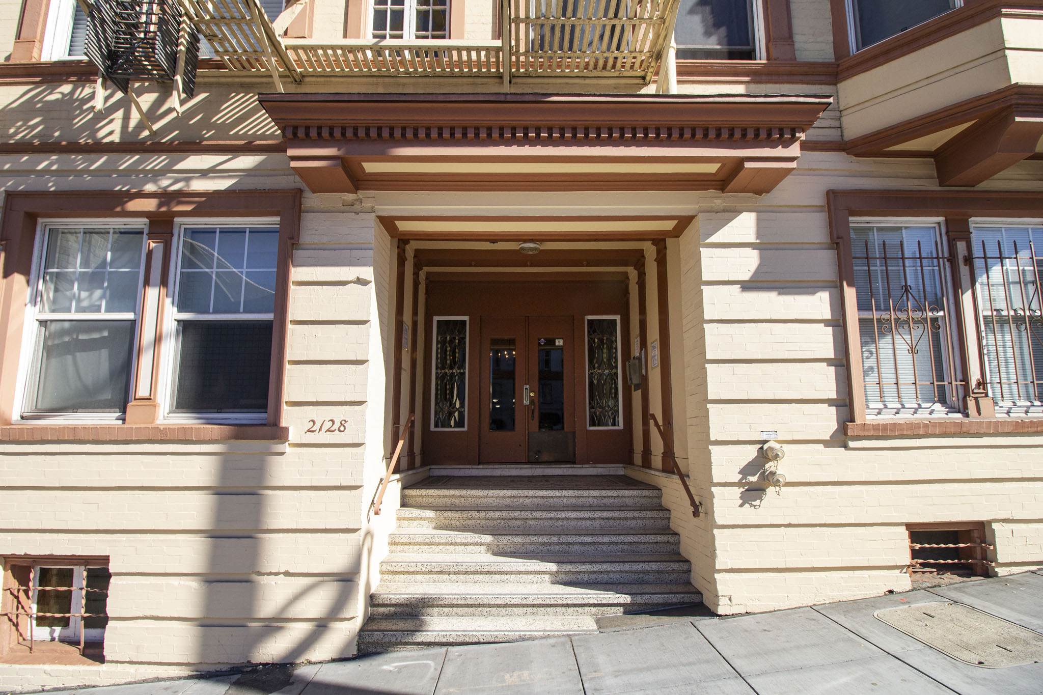 A beige building with a brown door and windows.