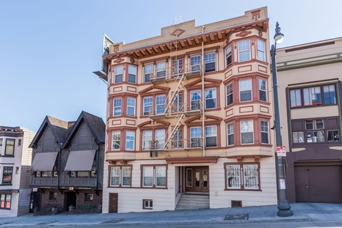 A tall building with a balcony on the second floor.