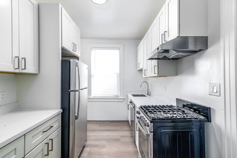 A kitchen with white cabinets and a black stove top oven.