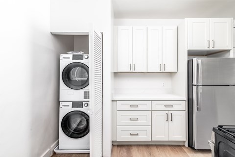 A white laundry room with a washer and dryer stacked on top of each other.