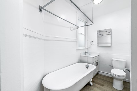 A white bathroom with a tub, toilet and sink.