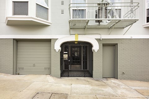 A building with a black gate and a balcony with a metal railing.