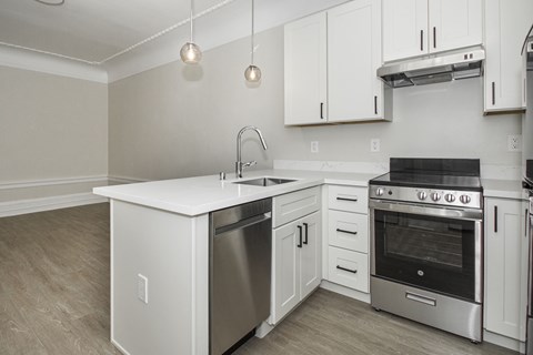 an empty kitchen with white cabinets and stainless steel appliances