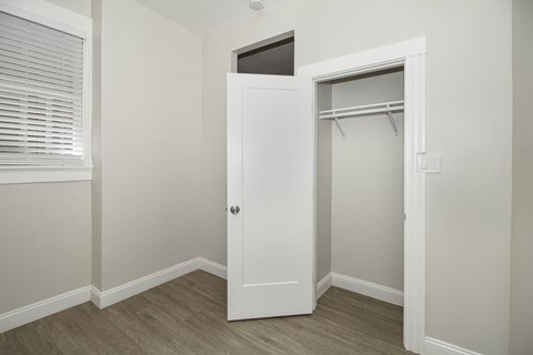 an empty bedroom with a closet and a window