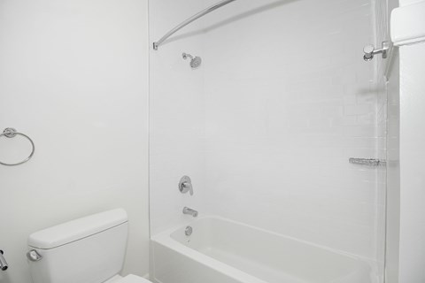 a white bathroom with a shower and a toilet
