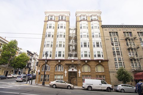 A brown building with a cross on the front and a white van parked in front.