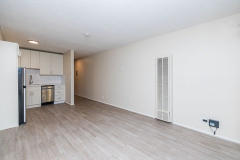 A spacious kitchen with white cabinets and a refrigerator.