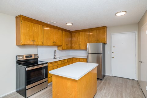 A kitchen with wooden cabinets and a white counter.