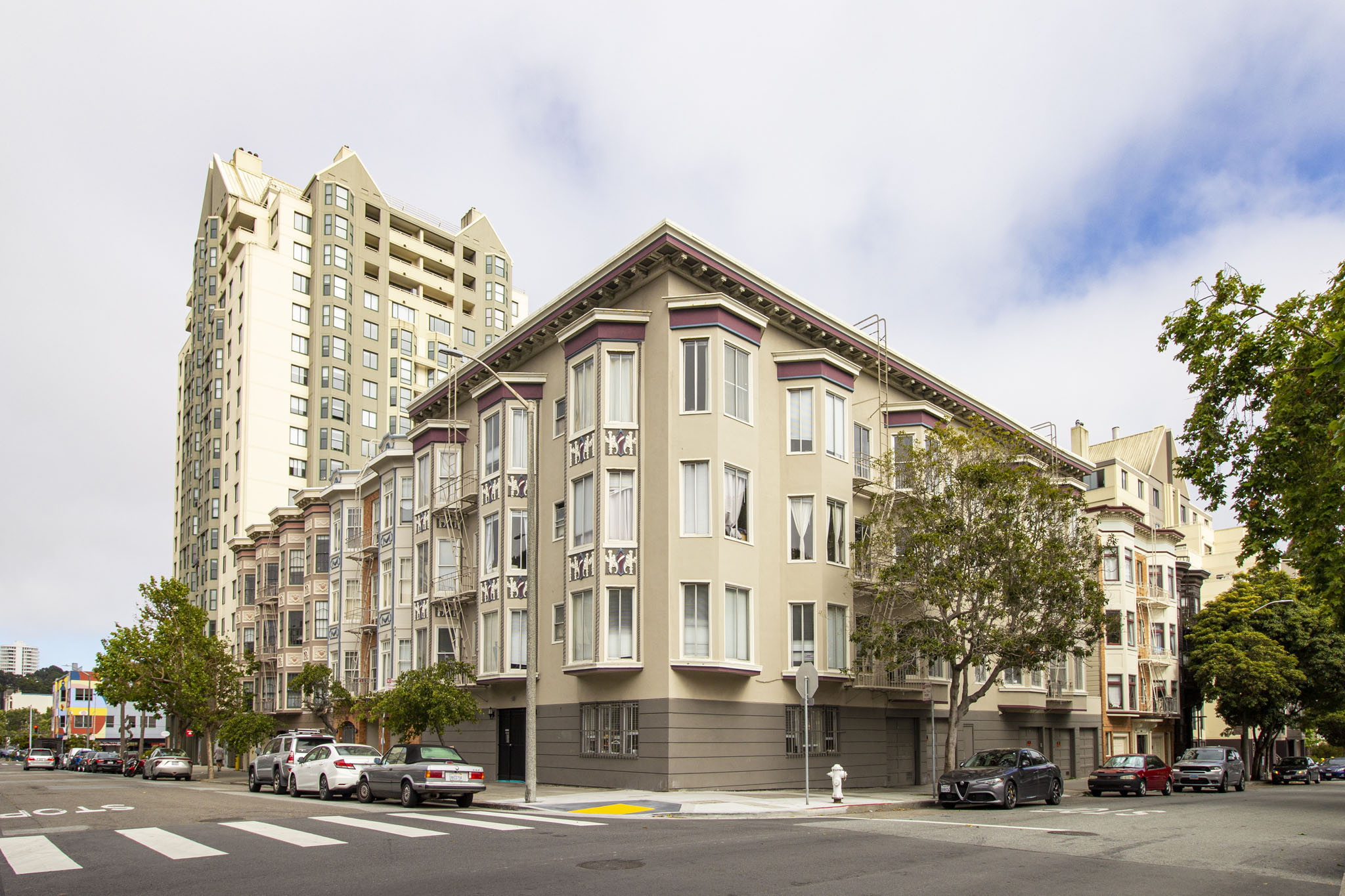 A street view of a building with cars parked in front.