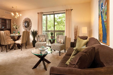A living room with brown couches and a glass coffee table.